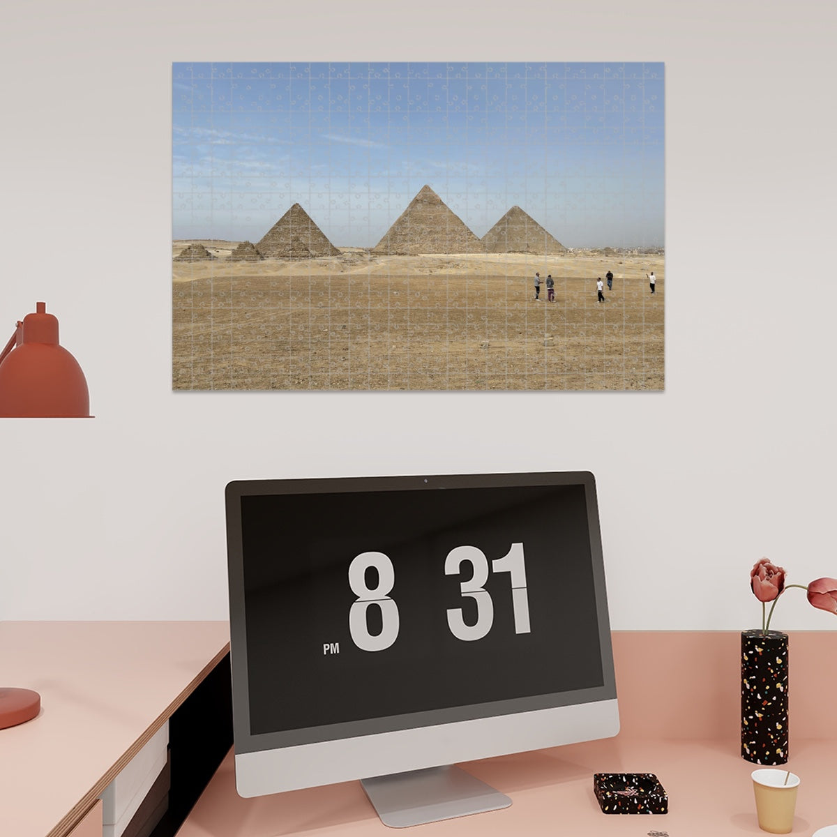 Full color image of the Pyramids of Giza under a blue sky with desert foreground and people in the distance.