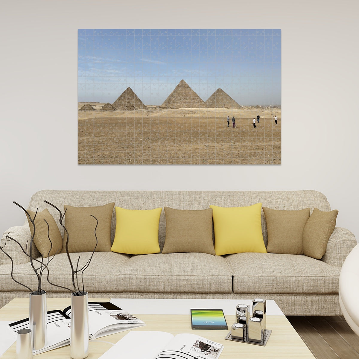 Full color image of the Pyramids of Giza under a blue sky with desert foreground and people in the distance.
