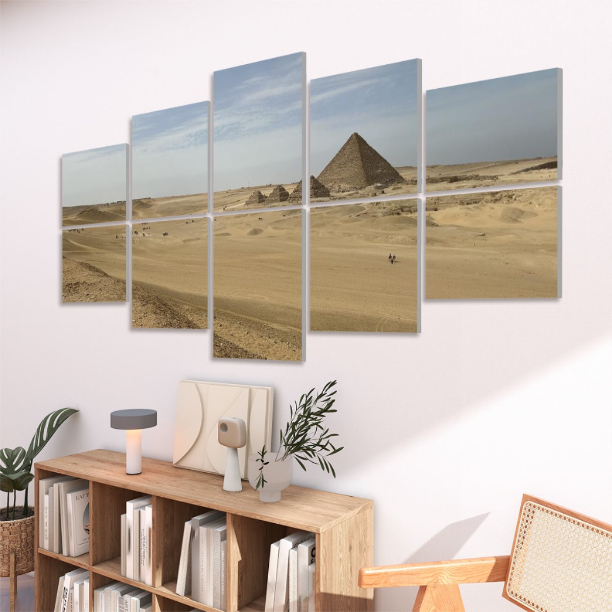 Angled panels mounted above a console in a modern room, the pyramid and dunes illuminated by dawn light against a neutral wall