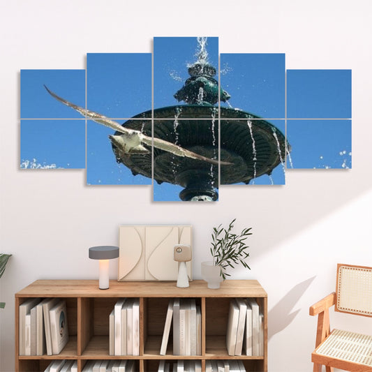 Ten panels on a white backdrop showing a Lisbon fountain with water streaming from a bronze spout into a stone basin. A white seagull glides across a bright blue sky above the fountain