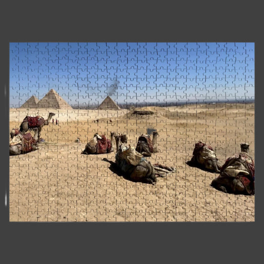 500-piece basswood puzzle of camels resting in the desert on Giza Plateau with pyramids and city in full color