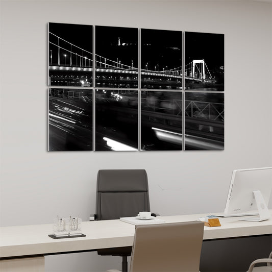 Left-angle view of Budapest Bridge wall art in full color with glowing night lights and riverside architecture.