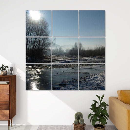 Front view of 9-panel acoustic wall art showing a peaceful winter stream winding through snowy banks, with bare trees and sunlight in a clear blue sky.