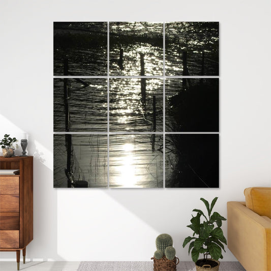 Front view of 9-panel acoustic wall art showing shimmering water reflecting bright light, with silhouetted fence posts and grasses in a moody, abstract scene.