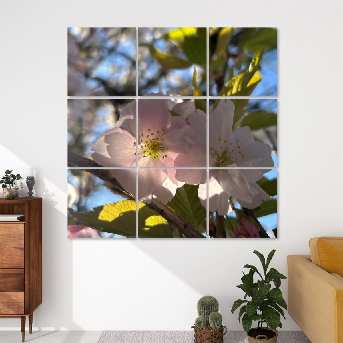 Pale pink cherry blossoms lit by soft sunlight with green leaves and blue sky, divided across 9 decorative sound absorbing wall panels.