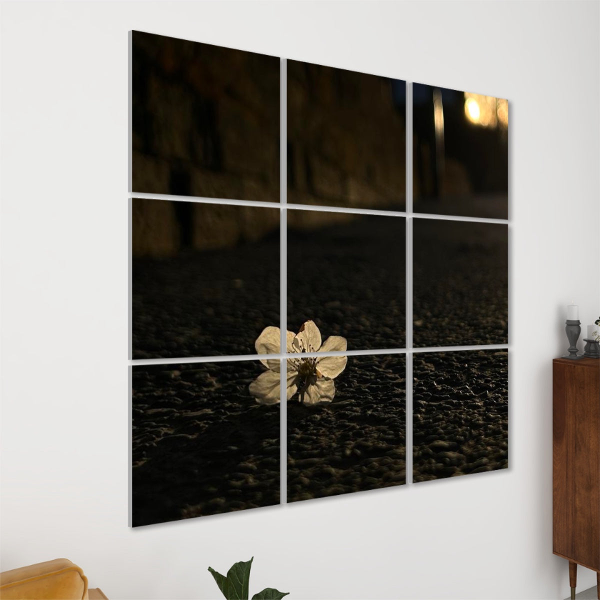Left-angle view of Asphalt Bloom wall art showing a white blossom on city pavement at sunset with golden highlights and soft shadows.