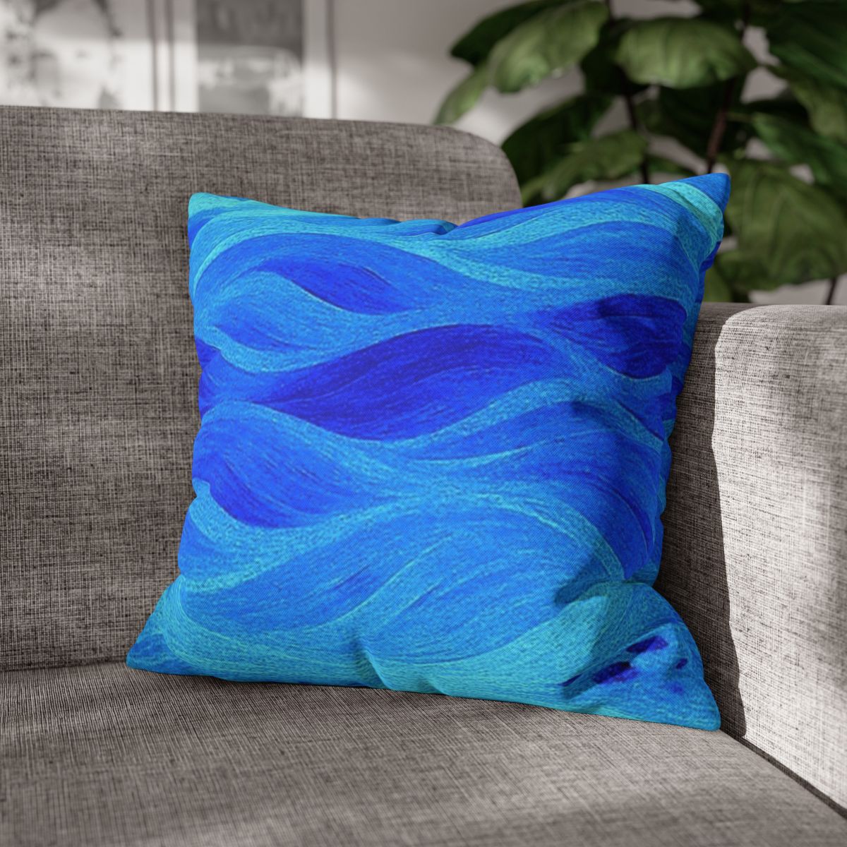 18" × 18" Abstract Wave pillowcase in Azure placed in the corner of a gray sofa