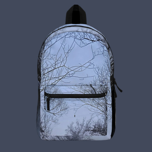 Front view of backpack featuring a foggy forest and lake reflection, framed by bare tree branches.