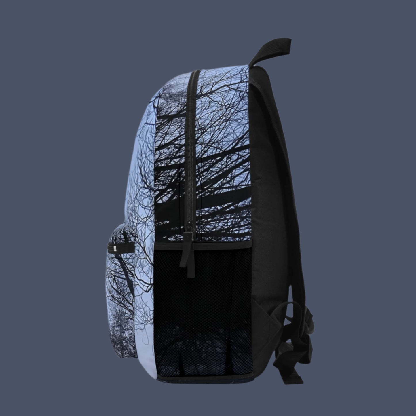 Right side of backpack with soft misty scene and dark tree silhouettes continuing across the panel.