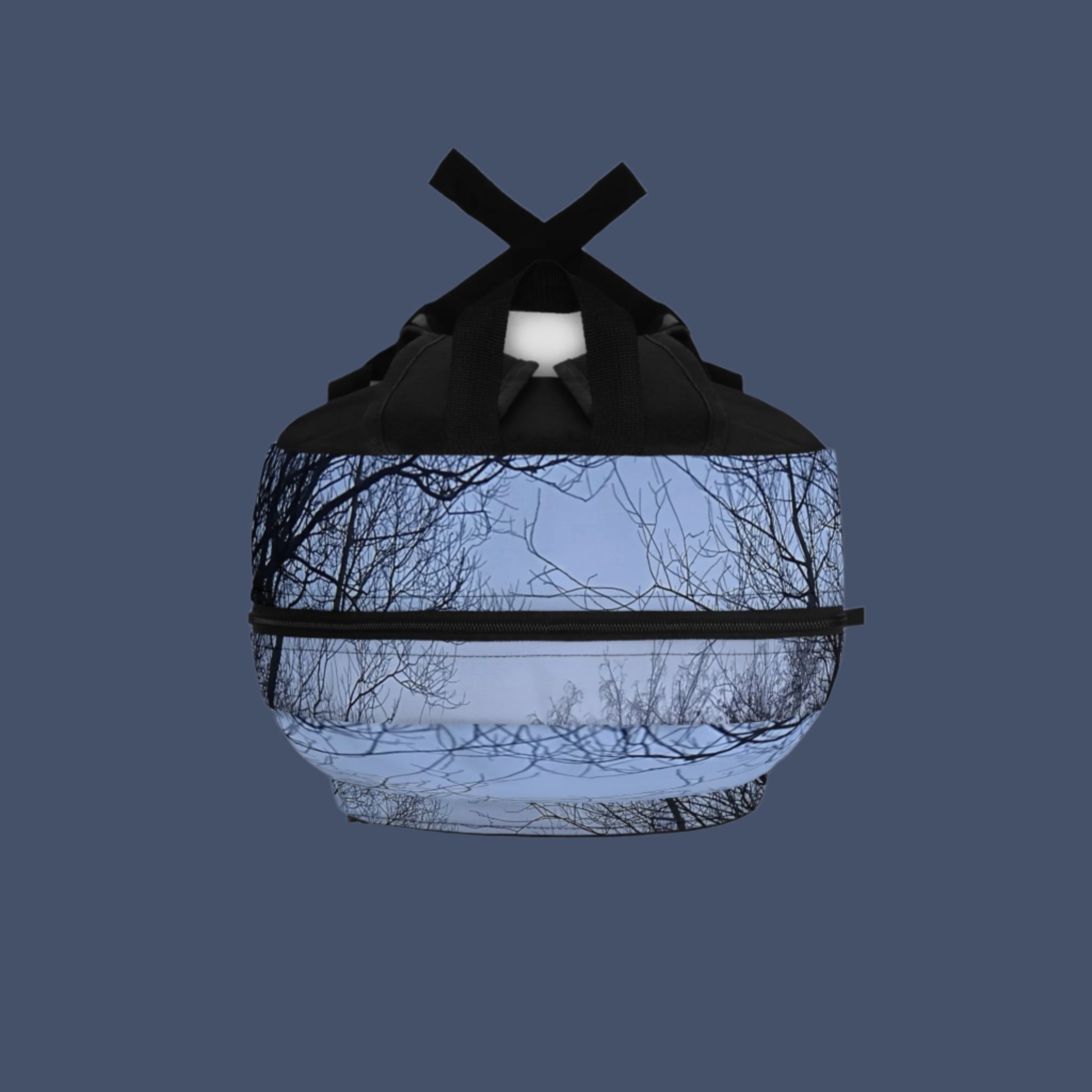 Top-down view of backpack with foggy forest print flowing over the top handle and zipper panel.