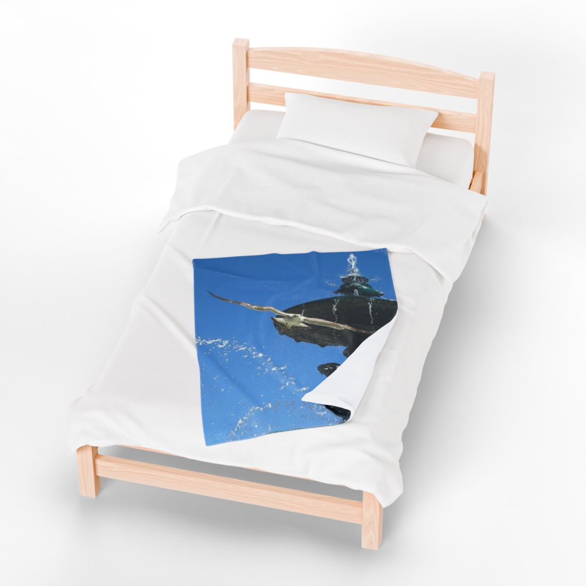 bird throw blanket featuring seagull in flight with blue sky and fountain in background