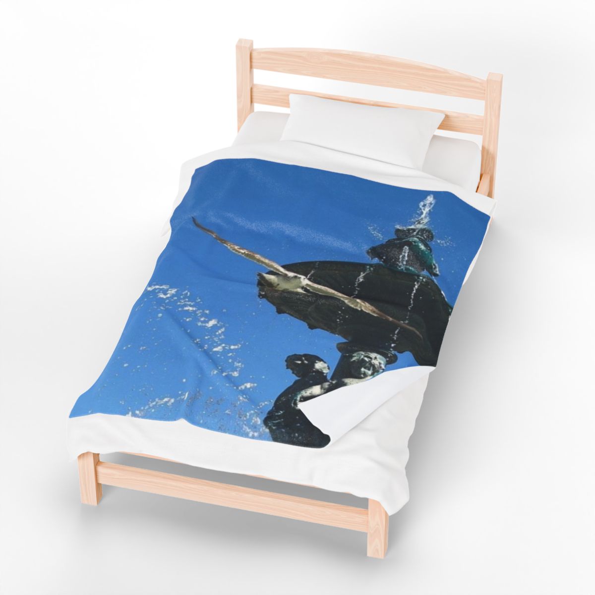 bird throw blanket featuring seagull in flight with blue sky and fountain in background