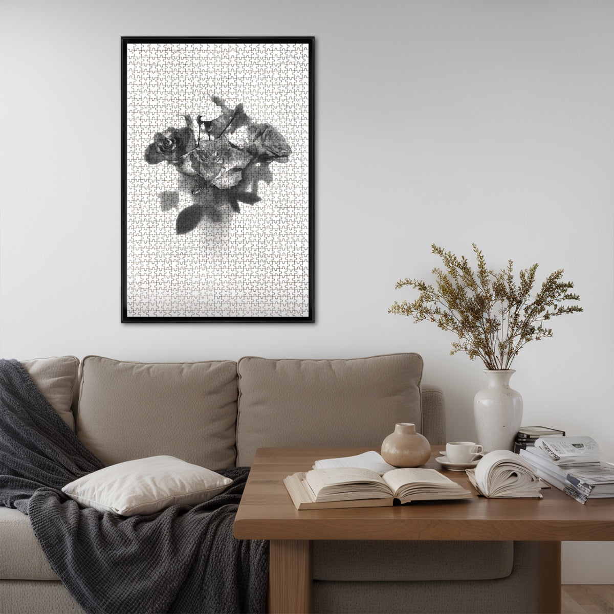 Living‑room mock‑up displaying the completed greyscale rose bouquet jigsaw puzzle framed above a sofa, illustrating finished size and monochrome elegance.