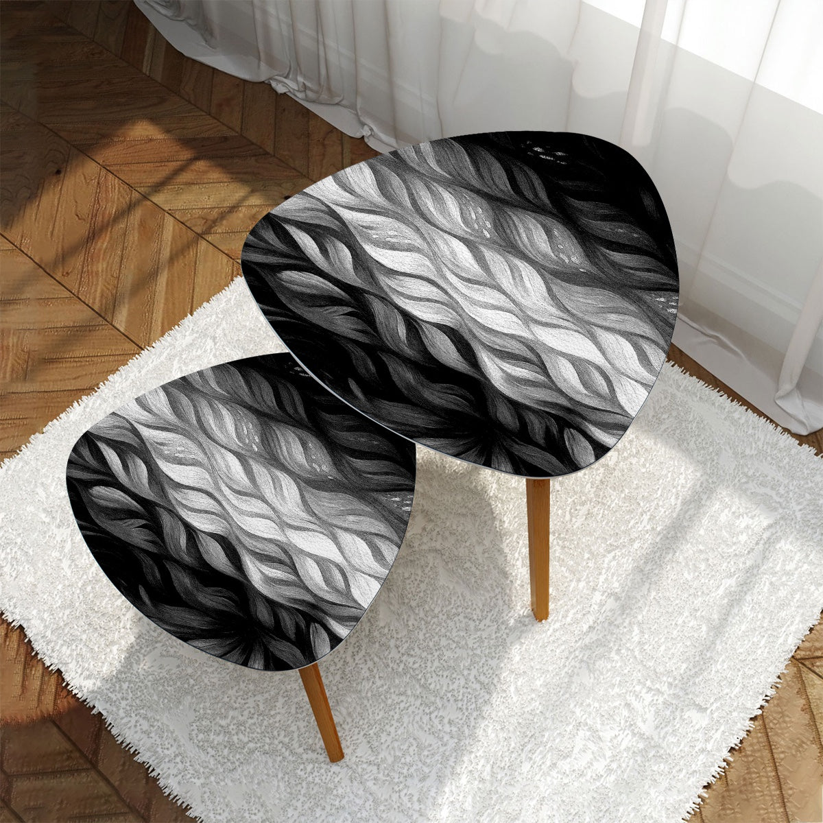 Nested triangle tables with black-and-white leather tabletops set on a white rug in front of a gray couch; bamboo legs visible