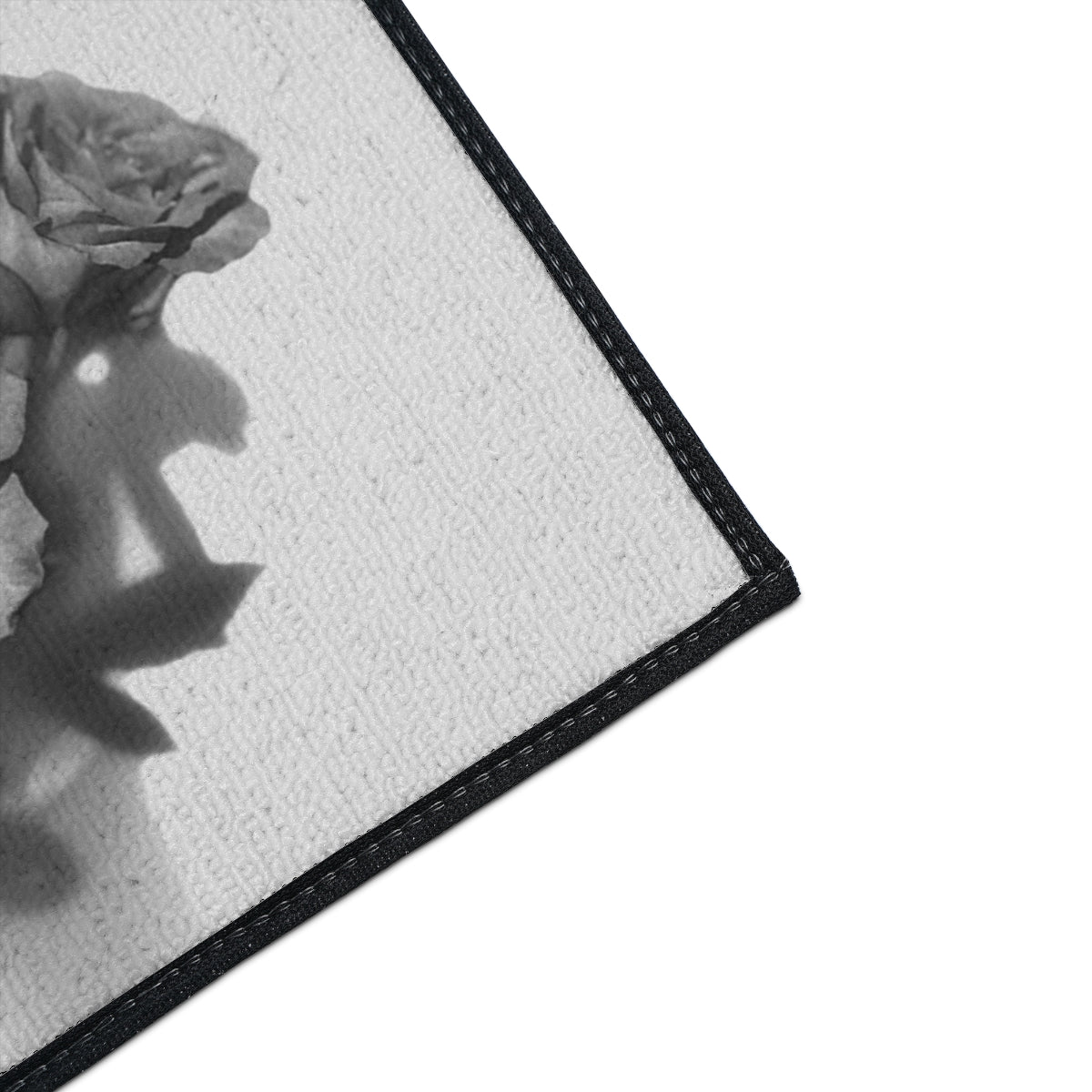 close up of the corner of heavy duty floor mat featuring black and white roses size: 18''x24''