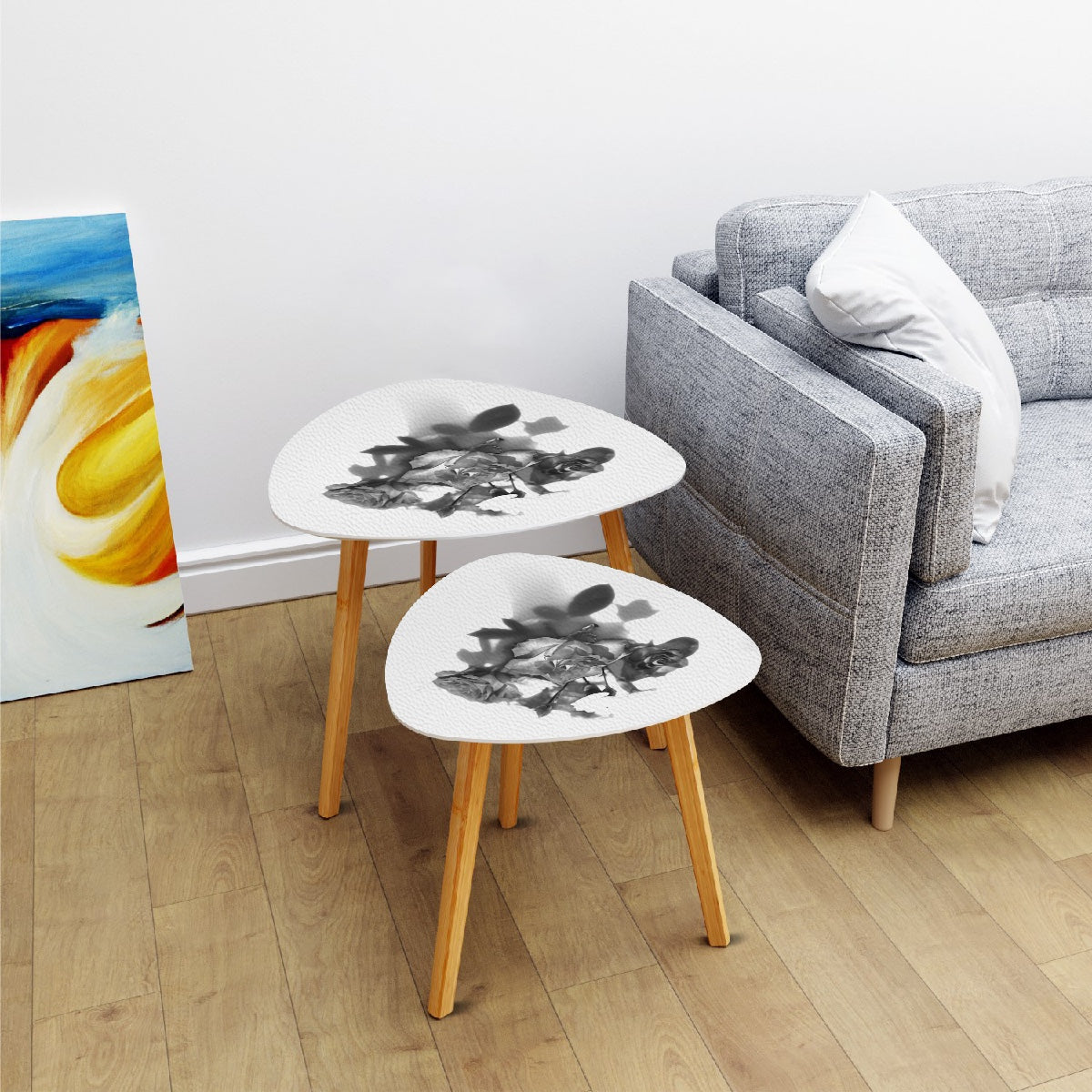 set of 2 black and white triangular coffee tables featuring bouquet of roses