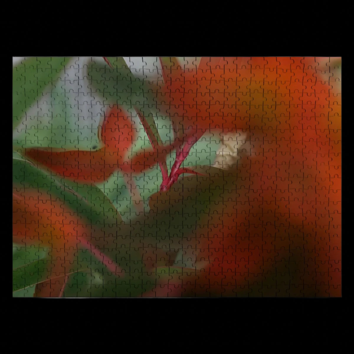 Wooden jigsaw puzzle of red and green foliage in full color with artistic bokeh, soft abstract nature scene