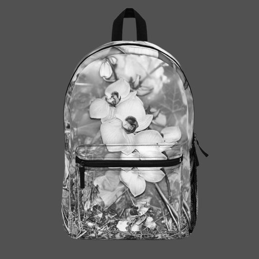 Front view of black and white orchid flower backpack with floral design centered across the main panel.