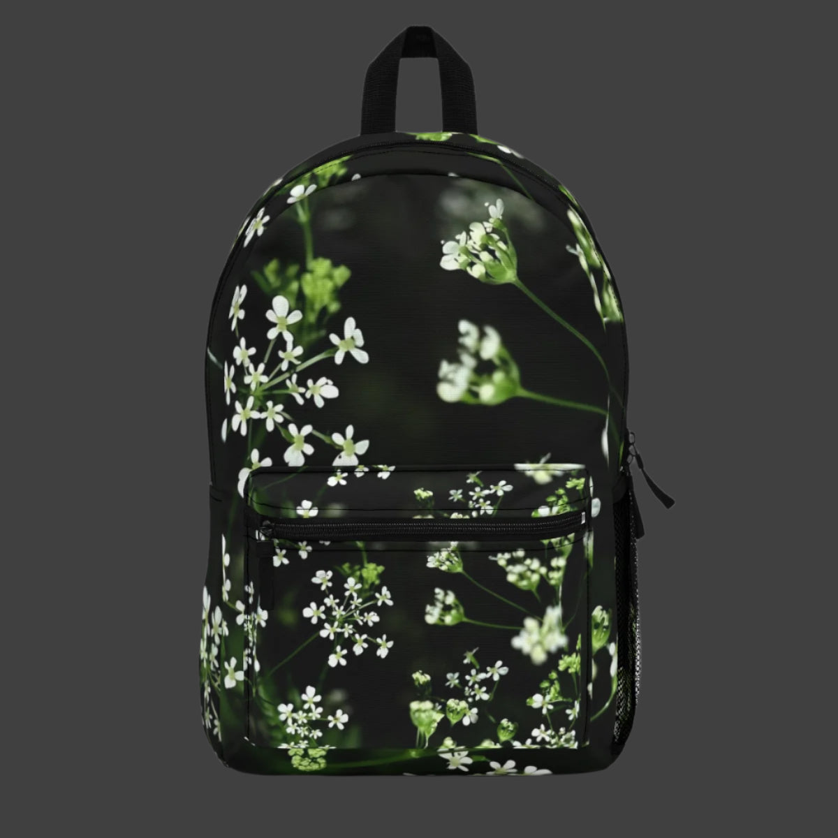 Full color backpack featuring a soft-focus photo of delicate white wildflowers on the main panel, with a natural green background.