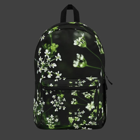 Full color backpack featuring a soft-focus photo of delicate white wildflowers on the main panel, with a natural green background.