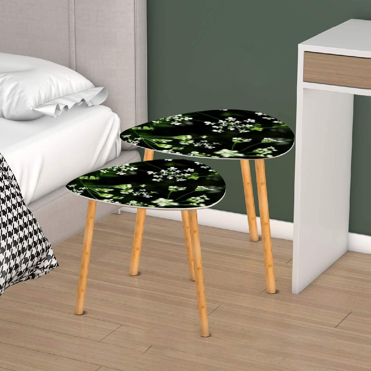 set of 2 floral triangular coffee tables featuring white little flowers on black background with green stems emerging from it