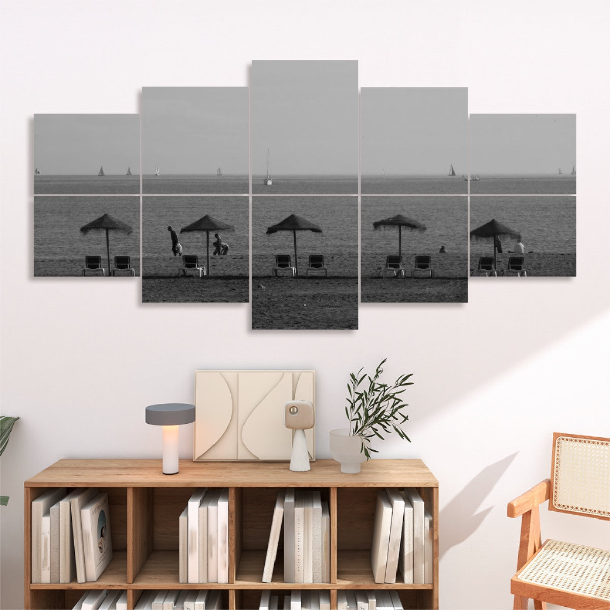 10 panels in grayscale depicting a sandy Málaga shore with straw umbrellas lounge chairs and boats on a calm sea