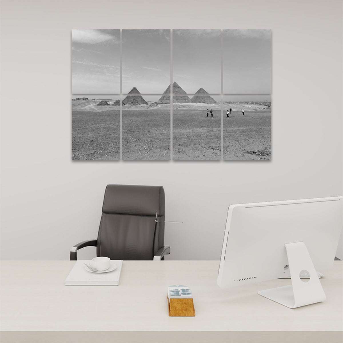 Black and white depiction of the pyramids in the desert, with human figures providing a sense of scale, printed on 8 sound-dampening panels.