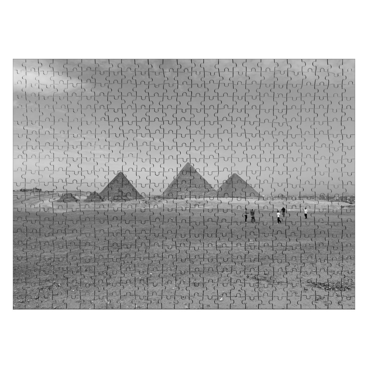 Greyscale image of the Pyramids of Giza with desert foreground and distant skyline, highlighting texture and shadow.