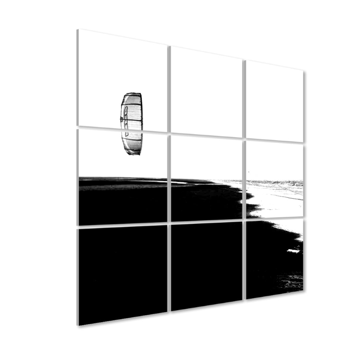 Left-angle view of 9-panel acoustic wall art featuring a single kite in the sky above a quiet beach at low tide, in black and white.