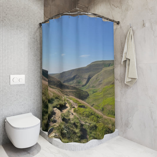 Tiled shower stall with curtain depicting a sunlit trail through green hills and clear blue sky