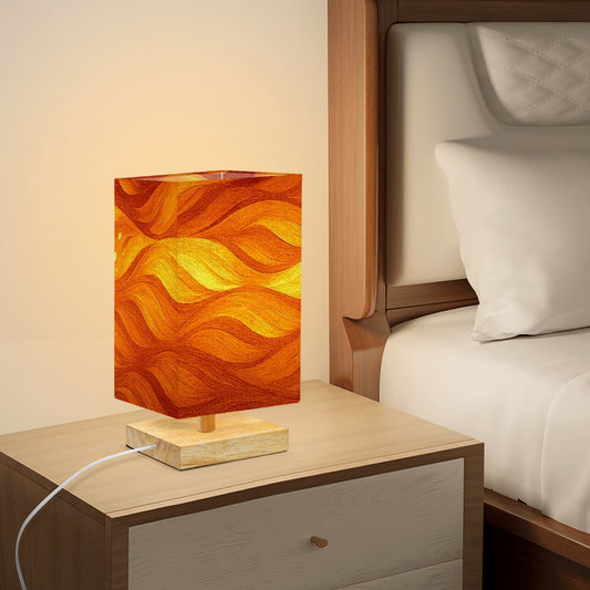 Square table lamp showing warm amber and ochre linen waves with subtle gold flecks on a rubber wood base
