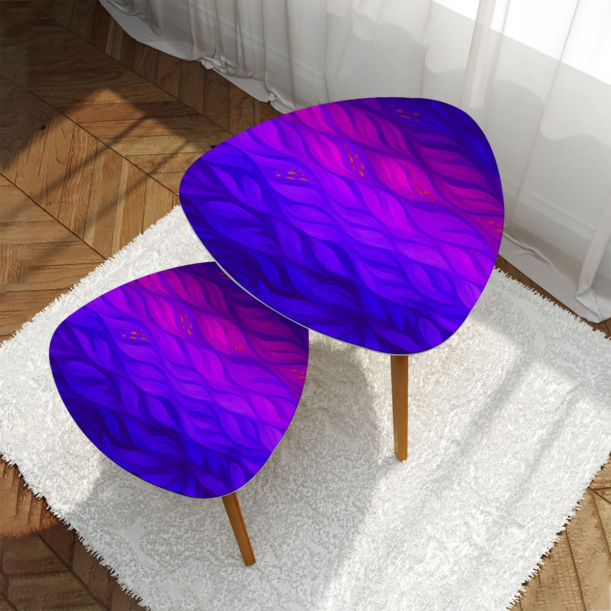 Nested triangles with vibrant purple-pink-blue leather tabletops on a white rug before a gray sofa; bamboo legs on hardwood floor