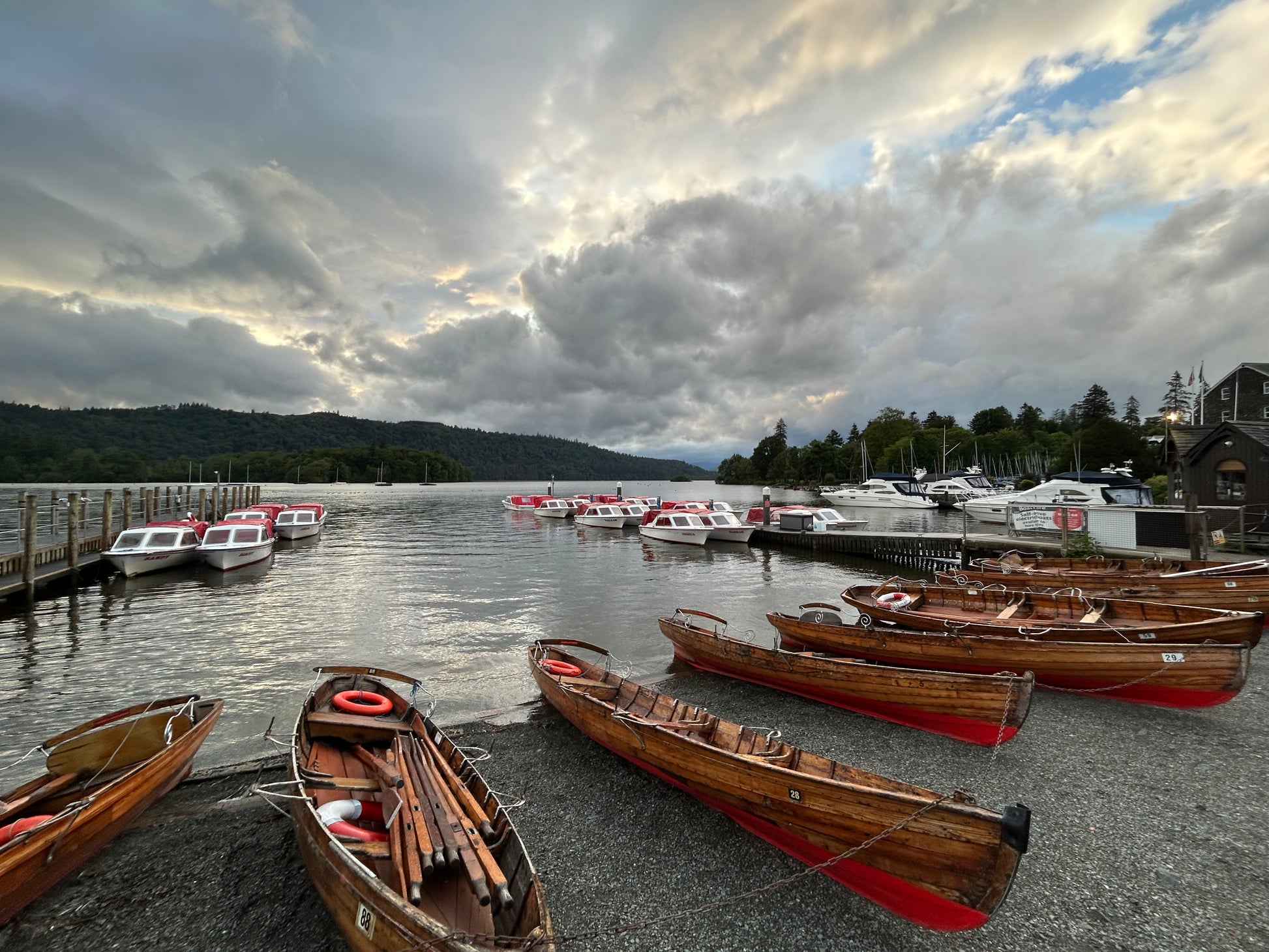 Rowboats on a dock with a lake and cloudy sky in the background