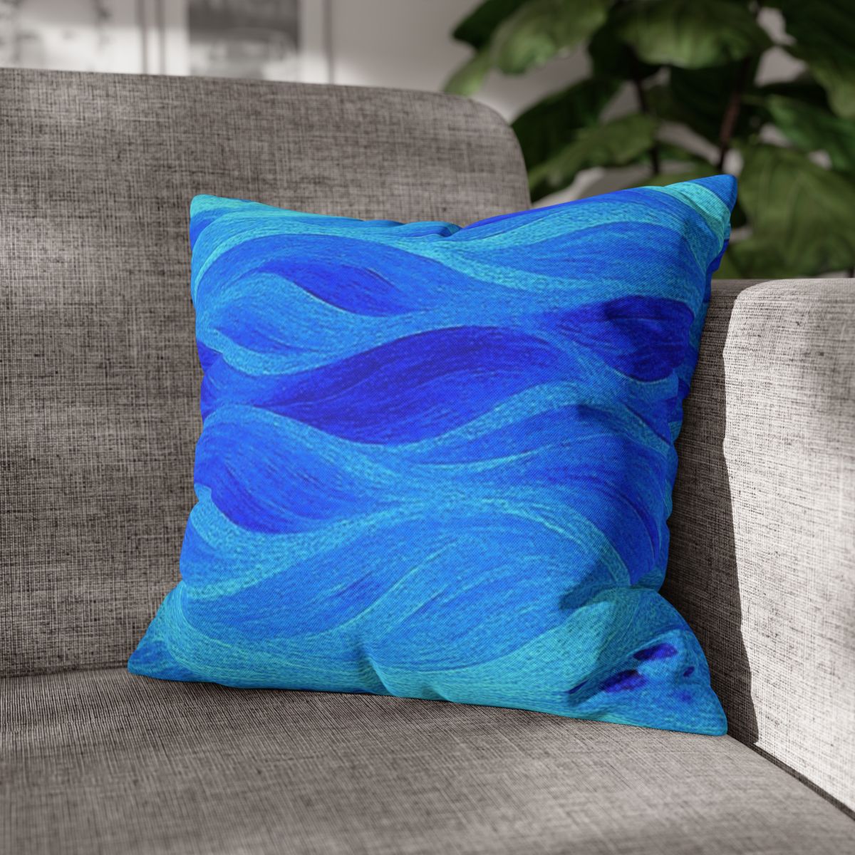 16" × 16" Abstract Wave pillowcase in Azure placed in the corner of a gray sofa