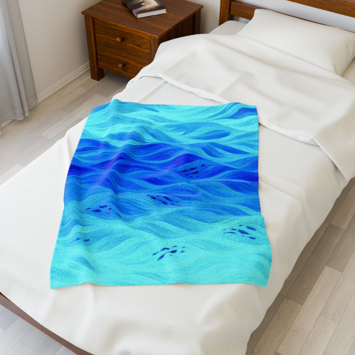 Azure version of Gilded Amethyst throw with layered sea blues and soft turquoise tones, shown folded neatly on a bed