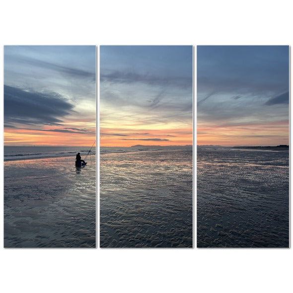 Beach Sunset Landscape Made in UK Triptych Canvas showing three panel coastal sunset with lone fisherman silhouette