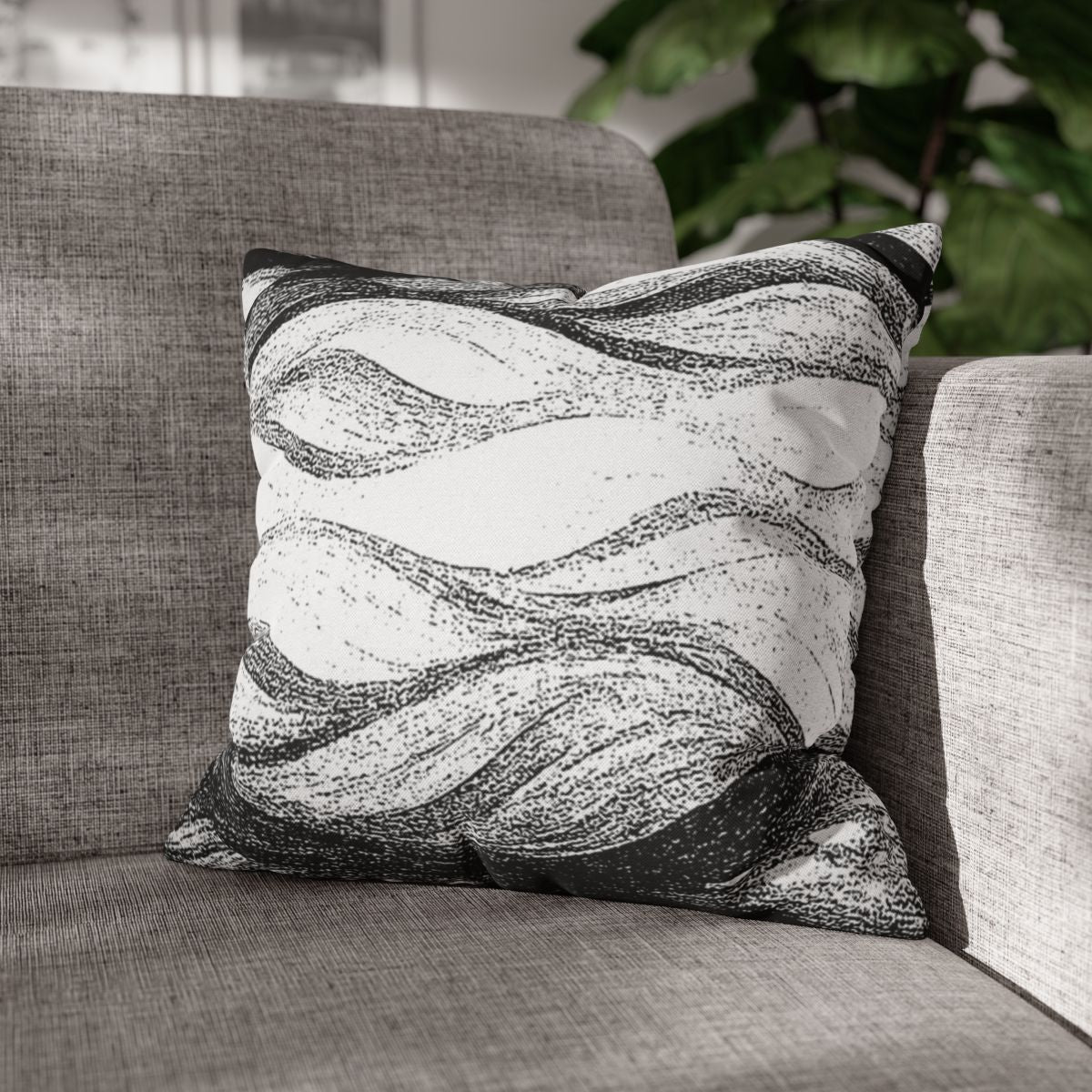 16" × 16" Abstract Wave pillowcase in Black & White placed in the corner of a gray sofa