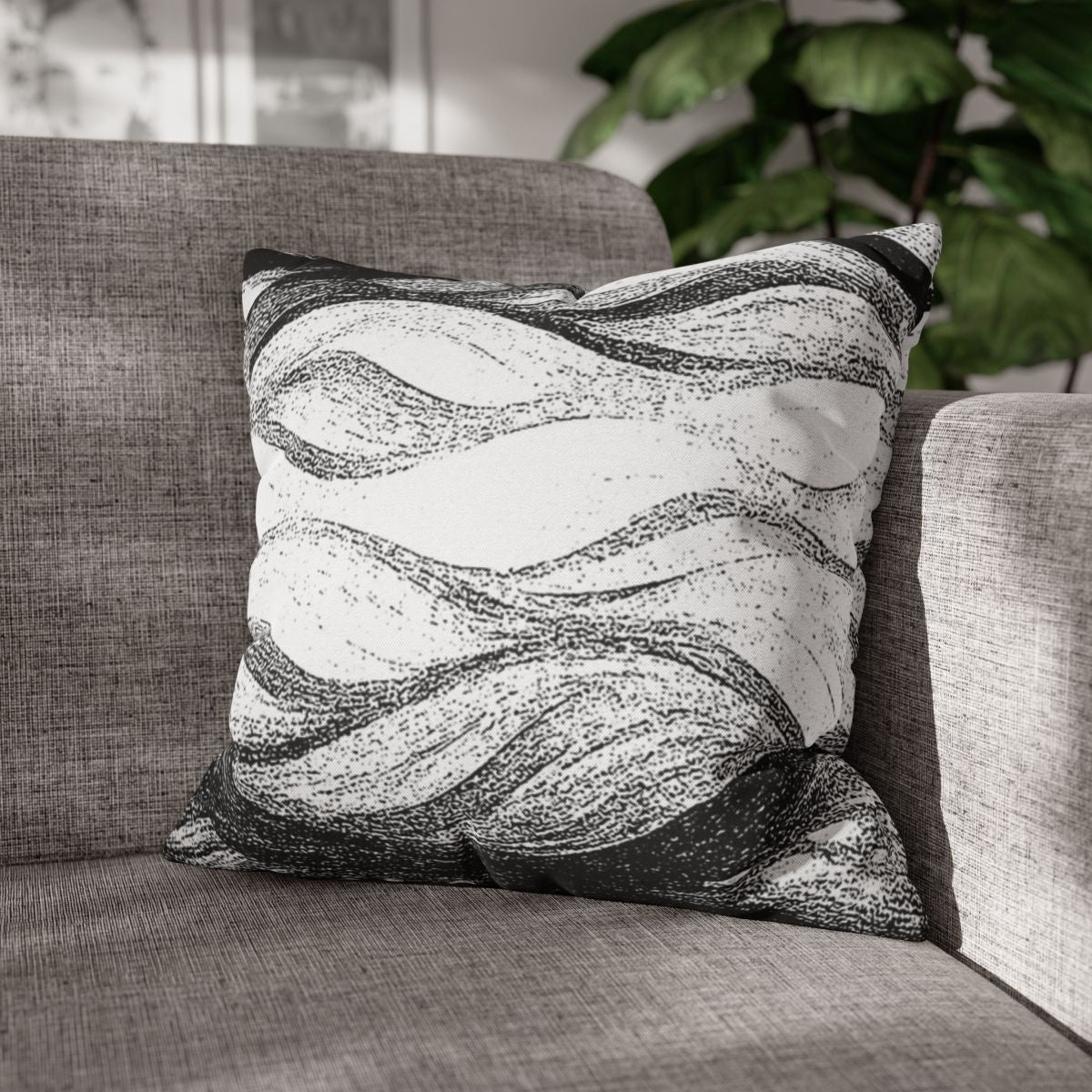 18" × 18" Abstract Wave pillowcase in Black & White placed in the corner of a gray sofa