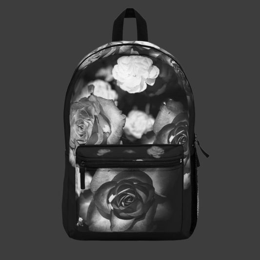 Front view of the black and white floral backpack featuring greyscale roses centered in a dramatic bloom against a dark background.