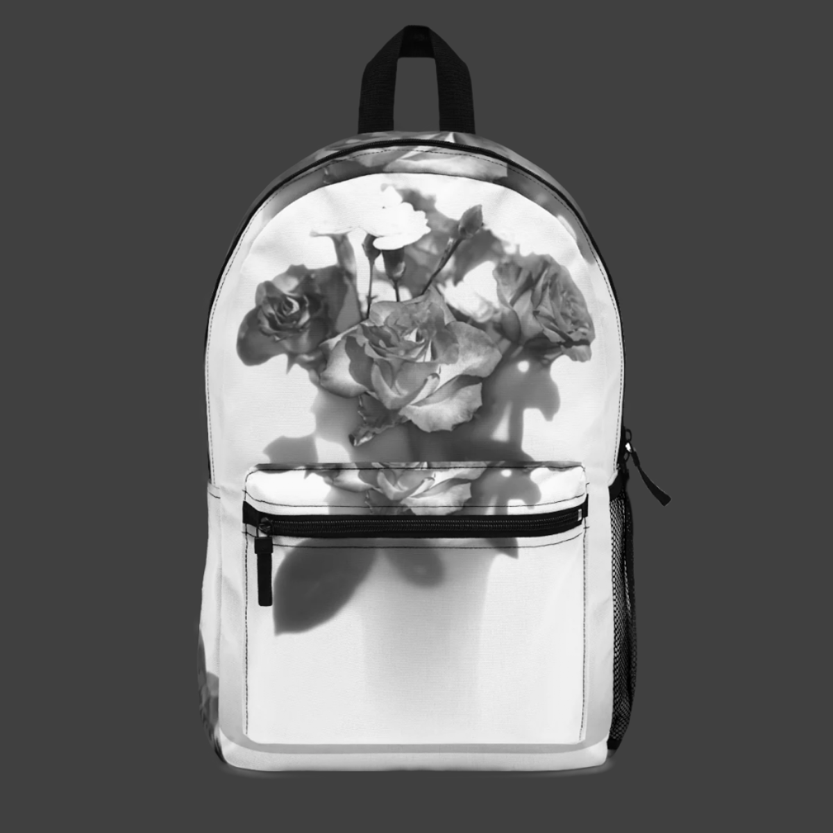 Front view of black and white floral backpack with greyscale rose bouquet design centered on the main panel.