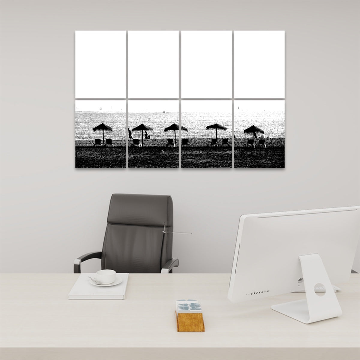 Black and white acoustic panels depicting a serene Málaga beach with straw umbrellas and lounge chairs under a clean, cloudless sky.