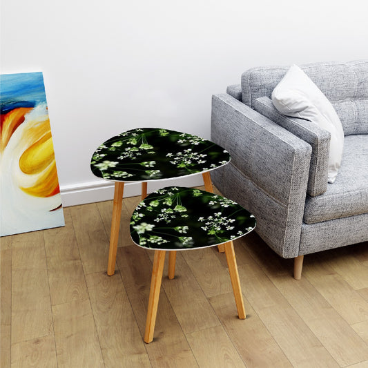 set of 2 floral triangular coffee tables featuring white little flowers on black background with green stems emerging from it