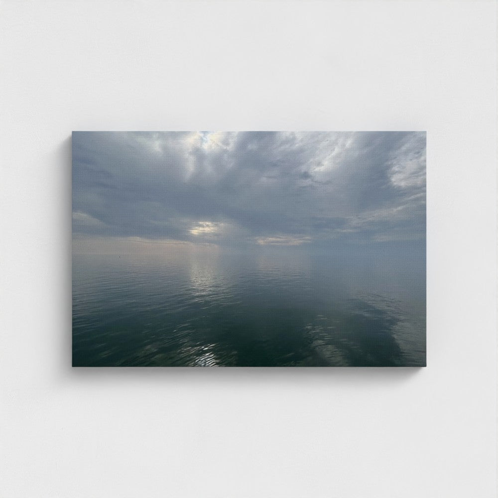 30''x20'' sustainable canvas art featuring a tranquil sea reflecting billowy clouds under a soft morning sky