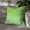 20" × 20" Abstract Wave pillowcase in Lemon & Lime placed in the corner of a gray sofa