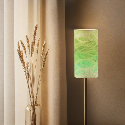 Tall cylindrical linen shade with purple and gold currents, mounted on a slender lamp base.