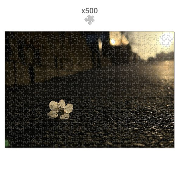Made in UK Floral Eco-Friendly Jigsaw Puzzle featuring a single white flower on a dark textured surface with sunlight 