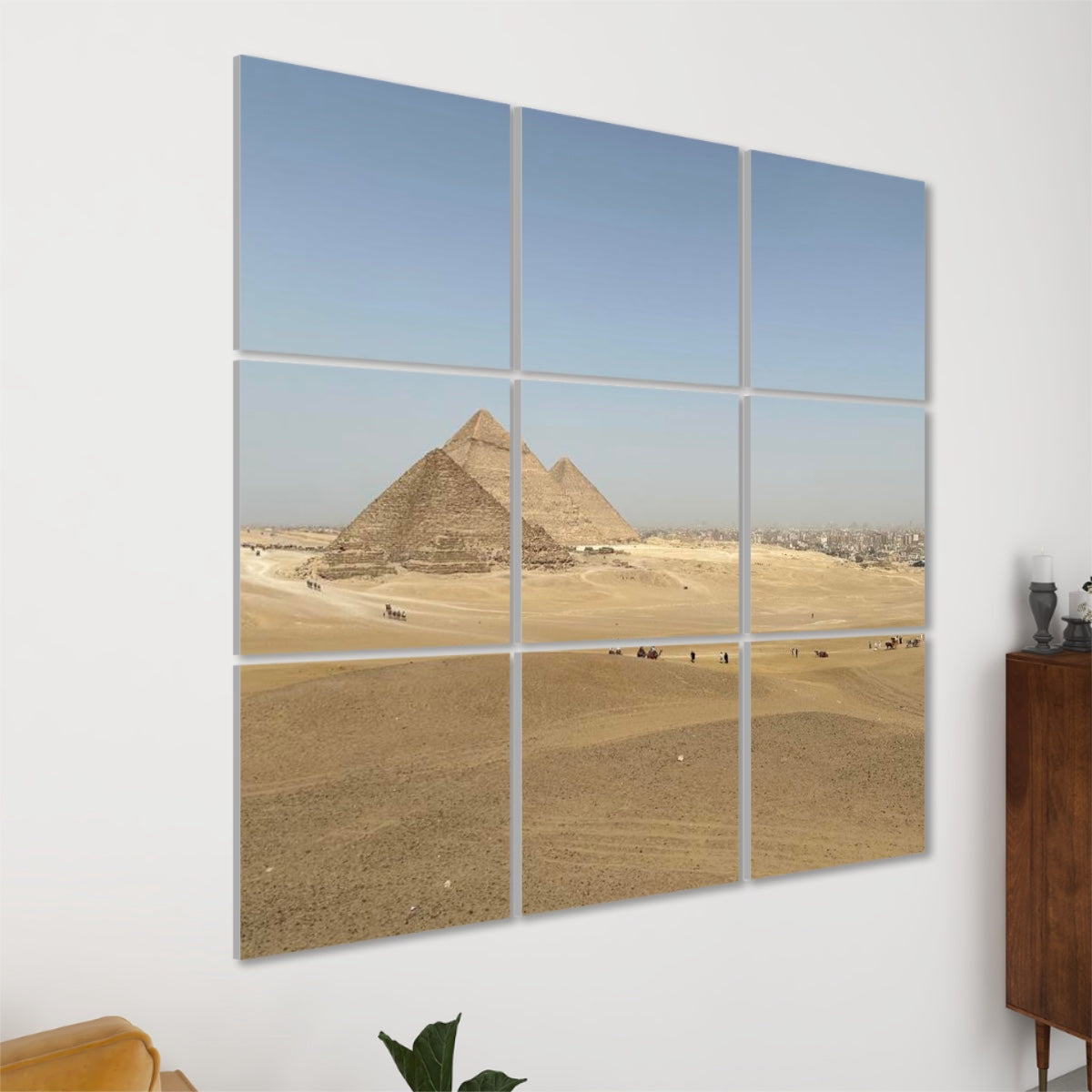 Left-side angled view of the full-color Distant Pyramids 9-panel acoustic wall art, showing panel depth and sunlight over desert dunes.