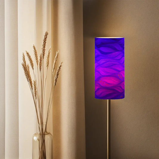 Tall cylindrical linen shade with purple and gold currents, mounted on a slender lamp base.