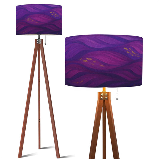 Tripod floor lamp with a linen shade patterned in swirling purple and pink amethyst currents, accented by gold flecks, atop a warm wood base.
