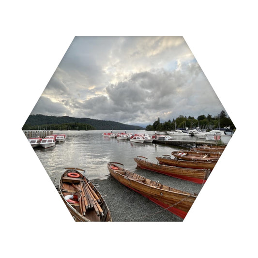 Hexagonal Windermere Lake Sound Absorbing Wall Panel by Papi's Canvas with wooden boats on lake under cloudy sky